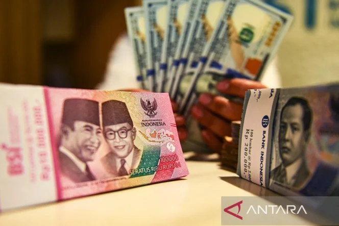 
 Petugas perbankan menunjukan uang pecahan rupiah dan dolar AS. ANTARA FOTO/Muhammad Adimaja/Spt/aa.