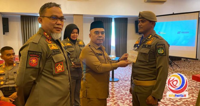 
 Asisten I Setkab Kutai Kartanegara, Akhmad Taufik Hidayat, didampingi Kepala Satpol PP Kukar, Arfan Boma, mengalungkan tanda peserta pelatihan penanganan huru-hara sebagai tanda dimulainya kegiatan. (Fairuzzabady/KutaiPanrita.id)